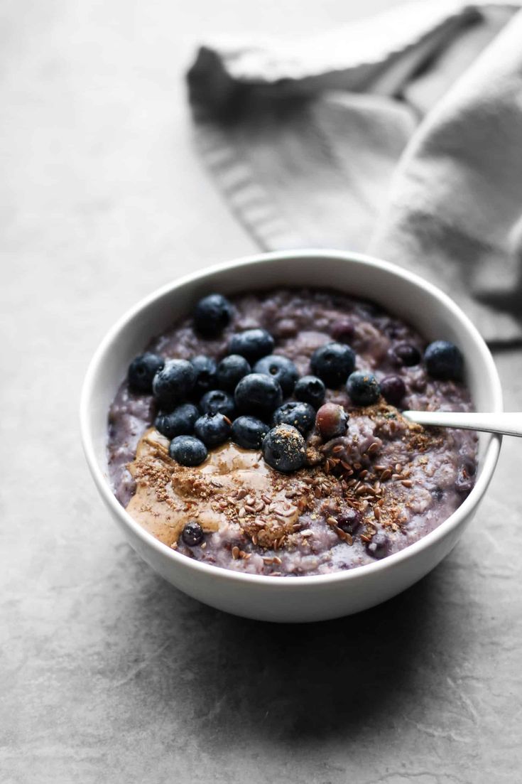 a bowl of oatmeal with blueberries and granola