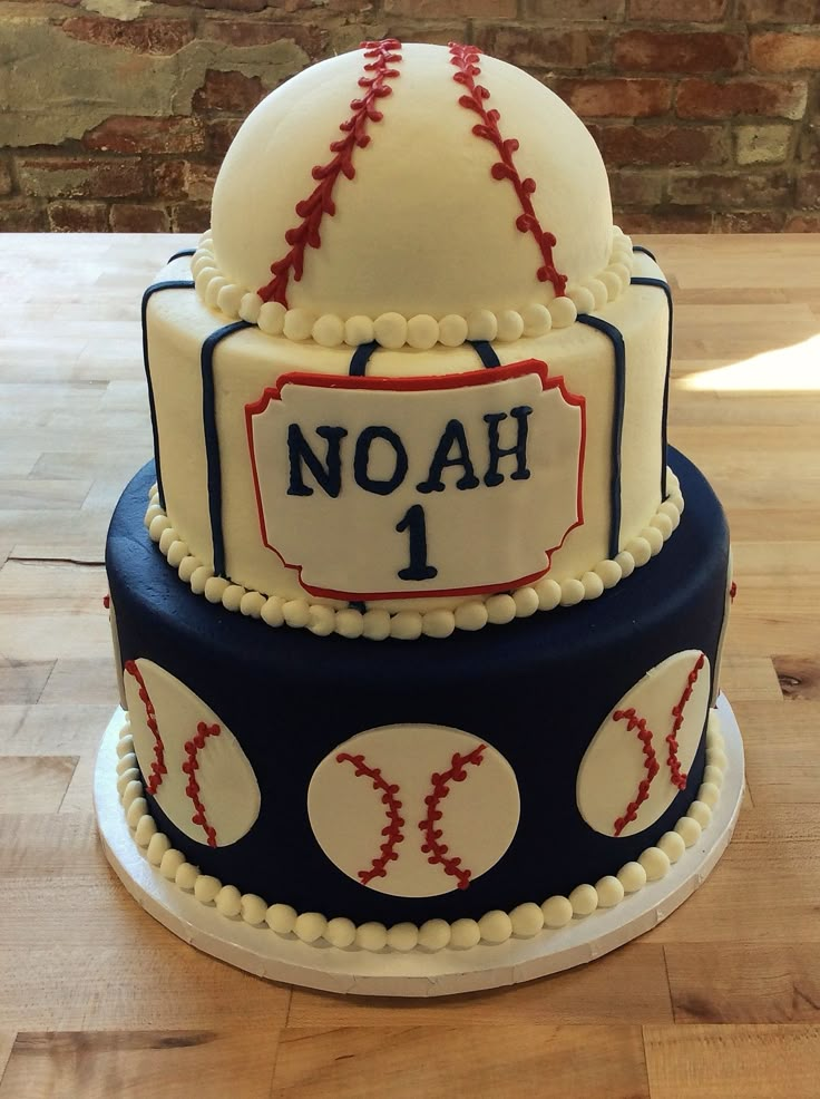 a three tiered cake with baseballs and nameplates on the top layer