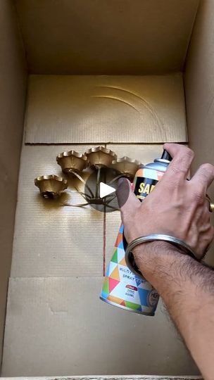 a man is holding a spray paint can in front of a box with gears on it