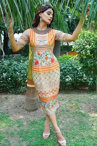 a woman standing in front of some palm trees and holding her arms out to the side