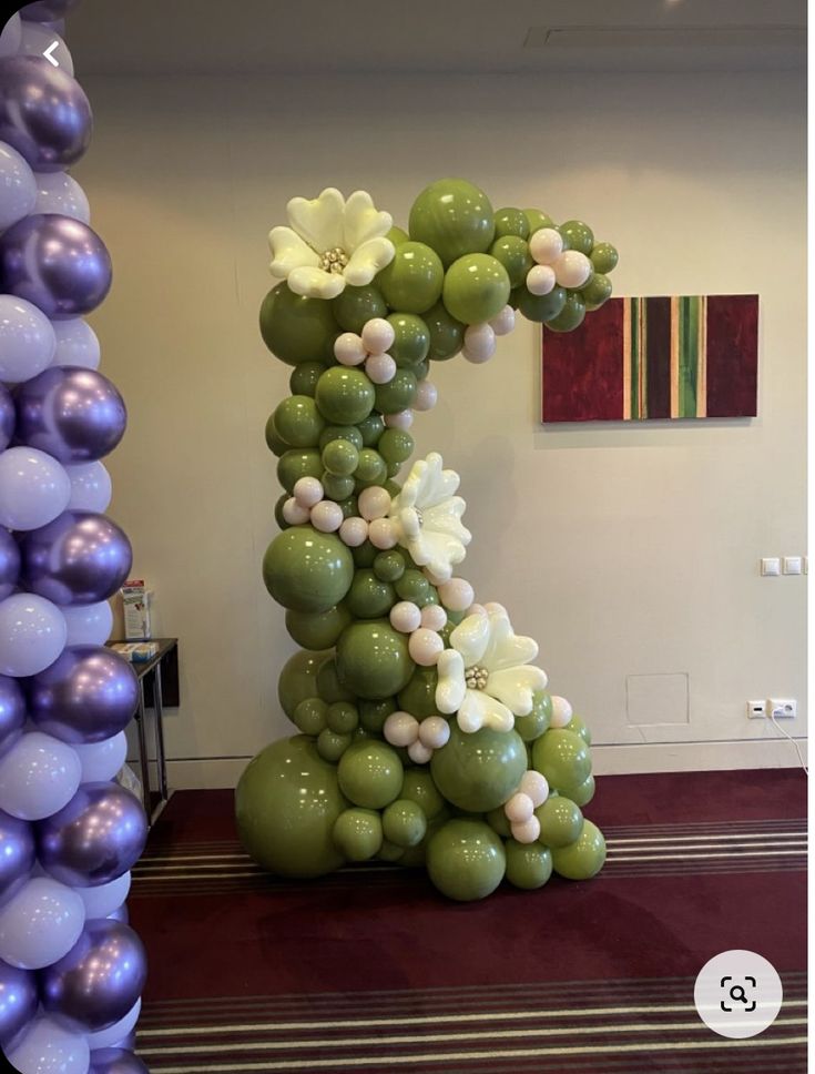 the number one balloon sculpture is decorated with flowers and balloons