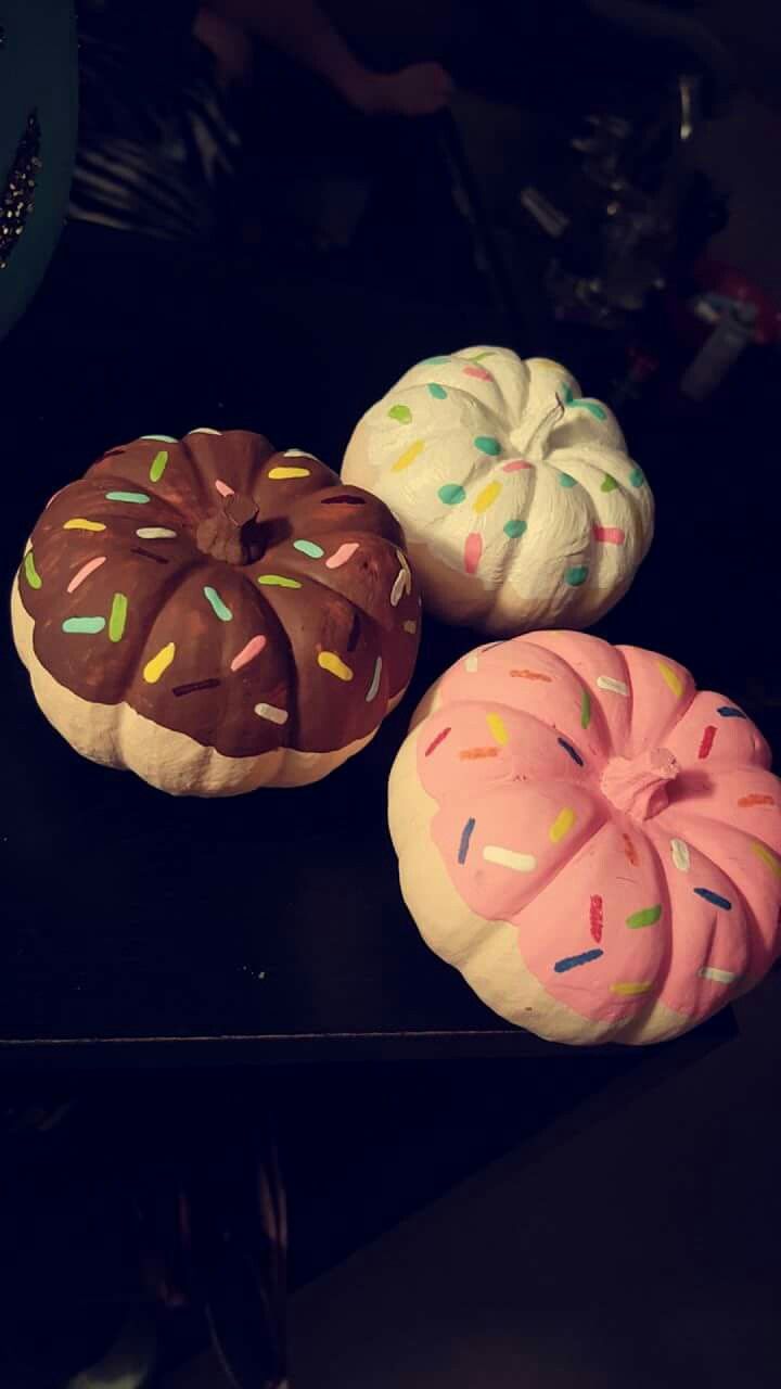 three donuts with sprinkles on them are sitting on a black table