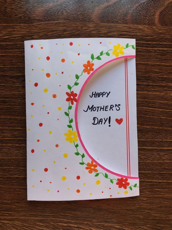 a mother's day card with flowers and hearts on the front, sitting on a wooden table