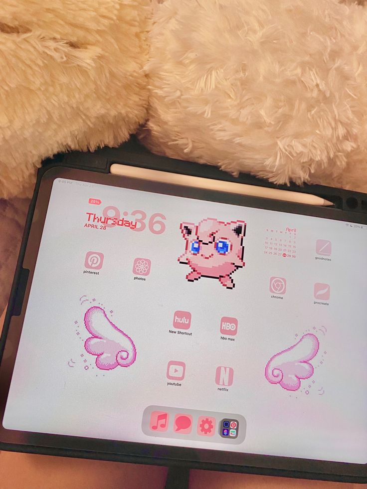 a teddy bear sitting next to a tablet with stickers on it's screen