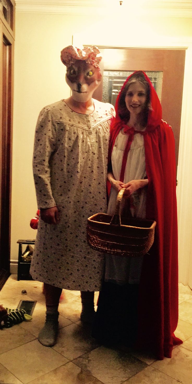 two people in costumes standing next to each other with a basket on their head and one person wearing a red cape