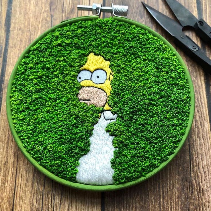 the simpsons face is on top of some green grass