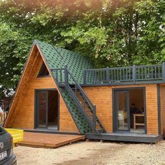 a small wooden cabin sitting in the middle of a forest with stairs leading up to it