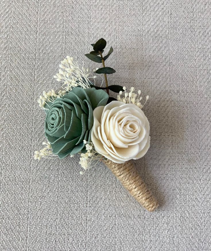 an ice cream cone decorated with flowers and greenery sits on a carpeted surface