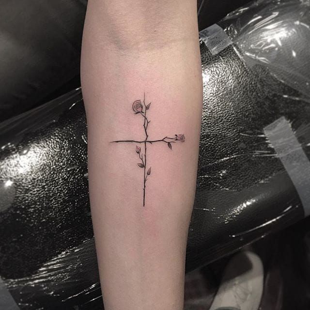 a cross with flowers on the arm