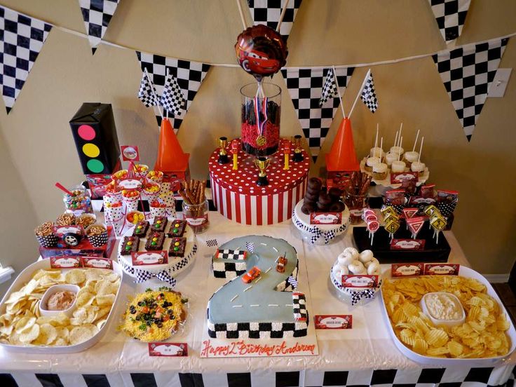 a table topped with lots of food next to a traffic signal sign and checkered flags