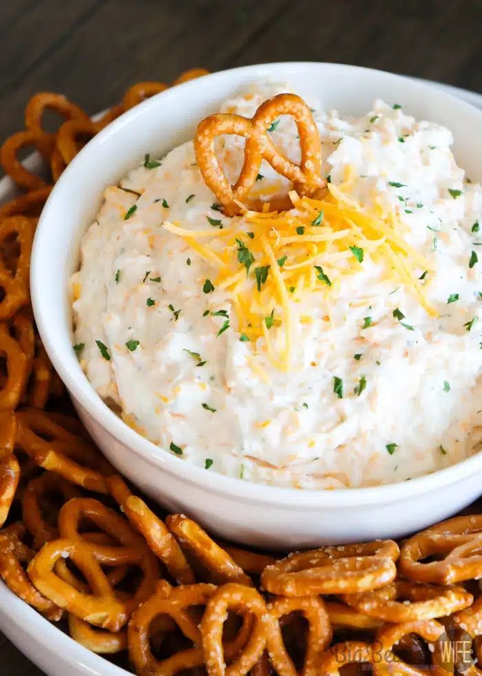 a white bowl filled with dip and pretzels