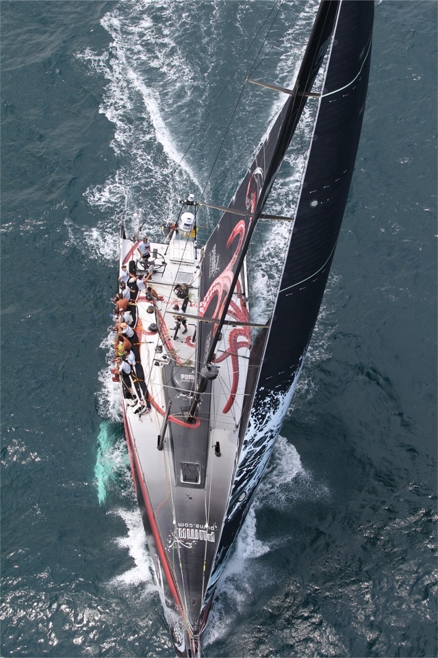 an aerial view of a sailboat sailing in the ocean with people on it's side