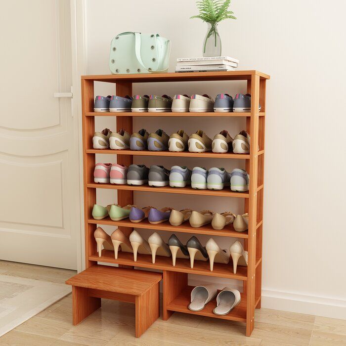 a wooden shoe rack filled with lots of shoes