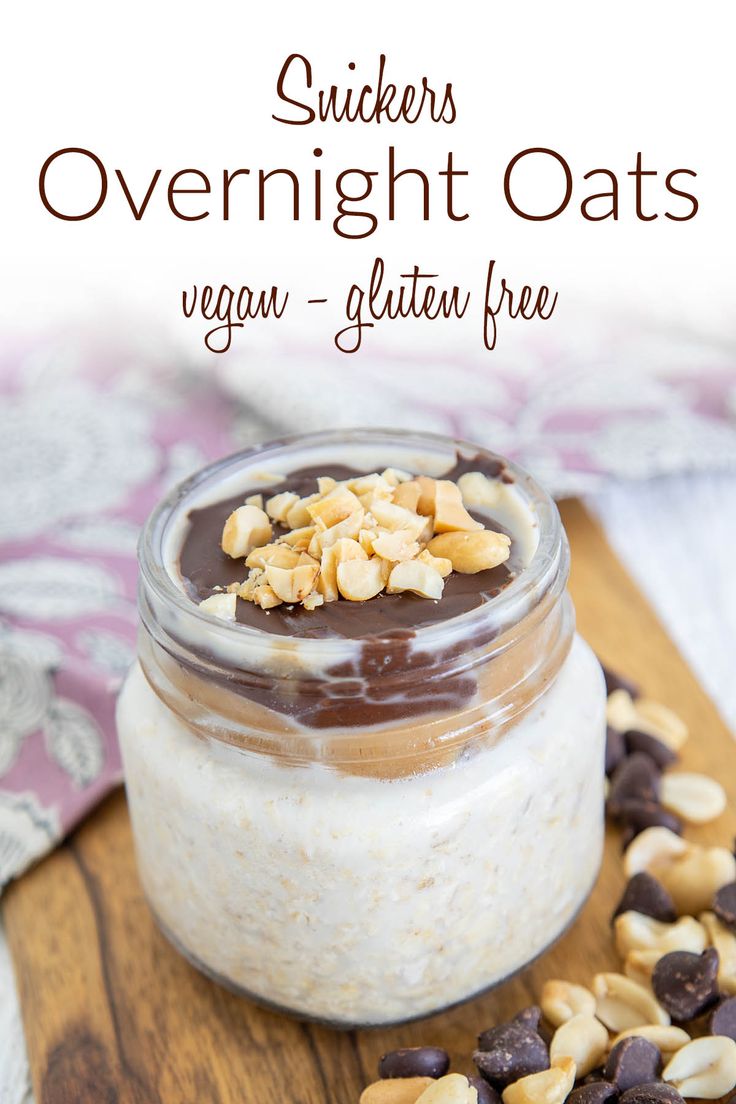 a jar filled with overnight oats sitting on top of a wooden cutting board