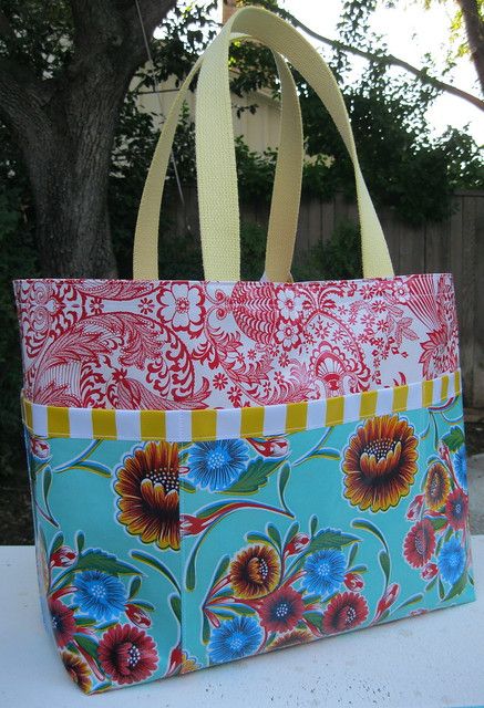 a colorful bag sitting on top of a white table next to a tree and fence