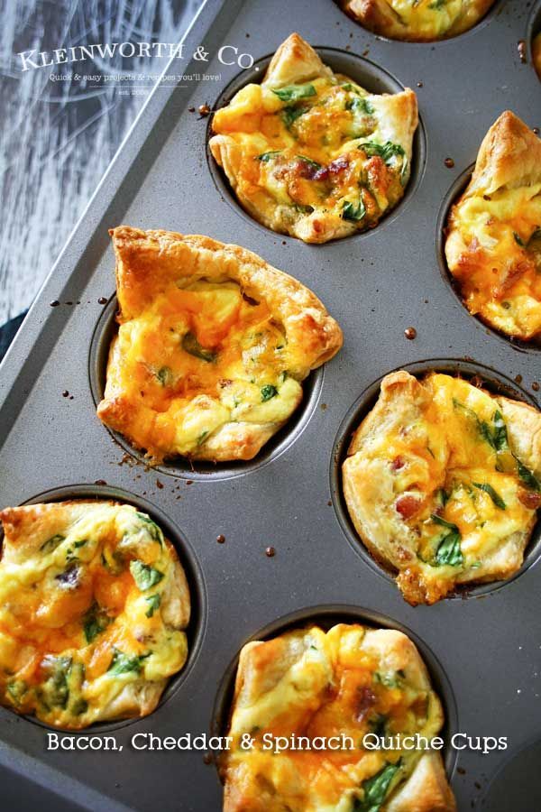 several small muffins with cheese and spinach toppings in a baking pan