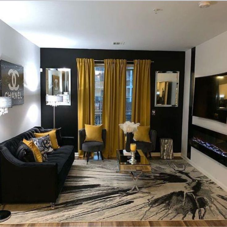 a living room filled with black furniture and yellow curtains