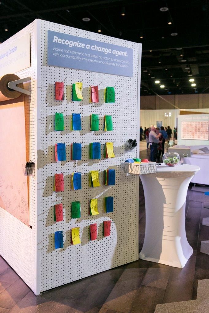 a display case with colorful sticky notes attached to the front and back of it in a large room