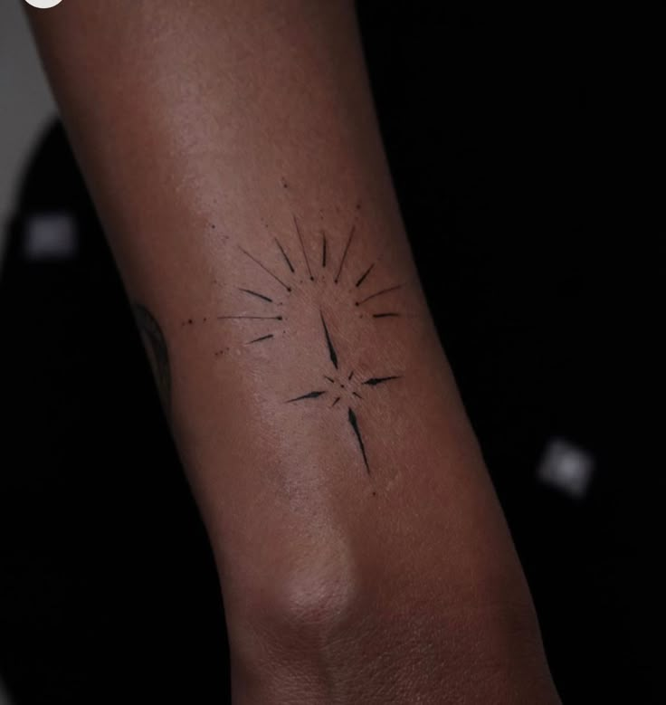 a person's arm with a small tattoo on the left side of their arm