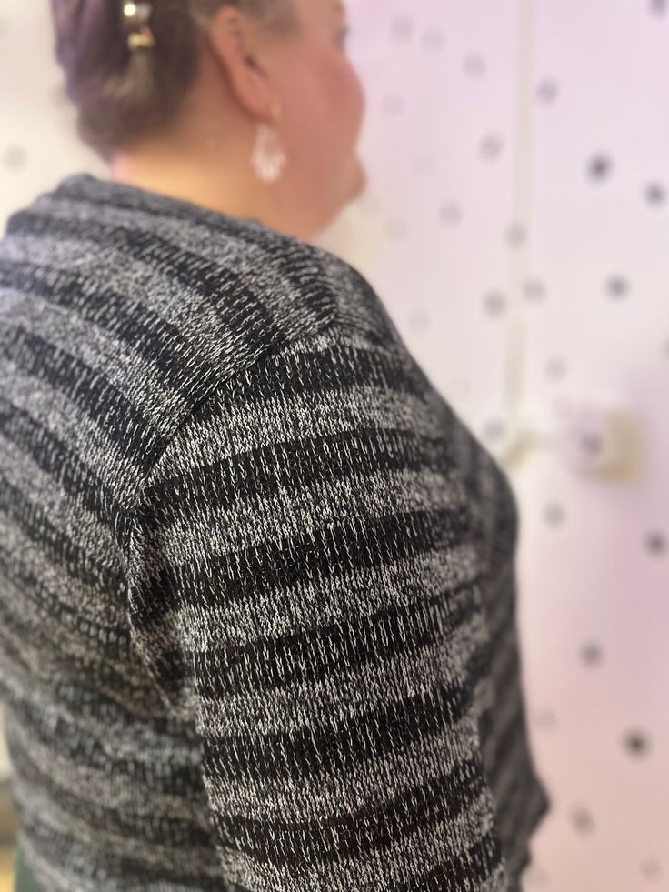 a woman standing in front of a wall with polka dots on it's walls