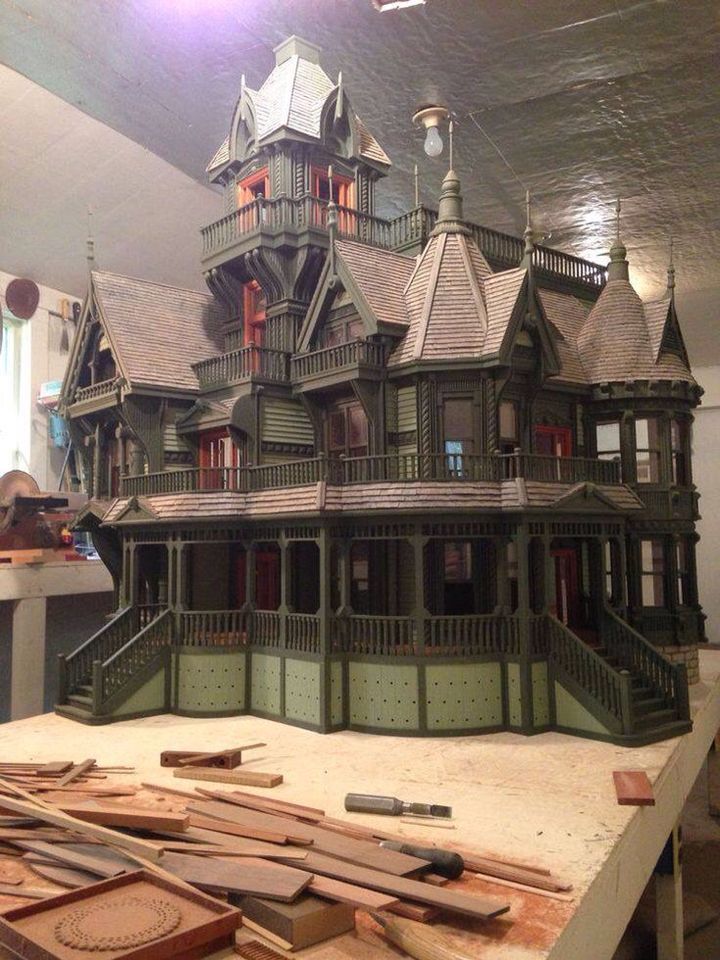 a model of a house on display in a room with lots of wood planks