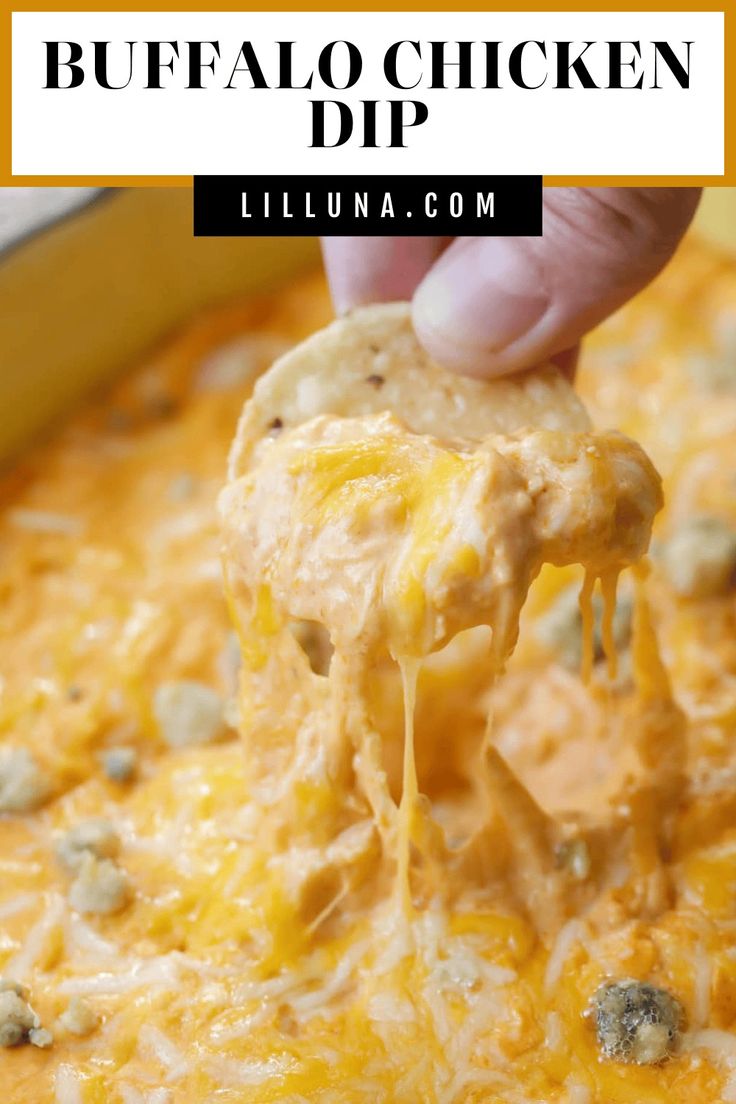 a hand holding a cheesy buffalo dip