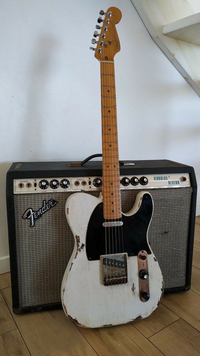 an old guitar and amp sitting on the floor