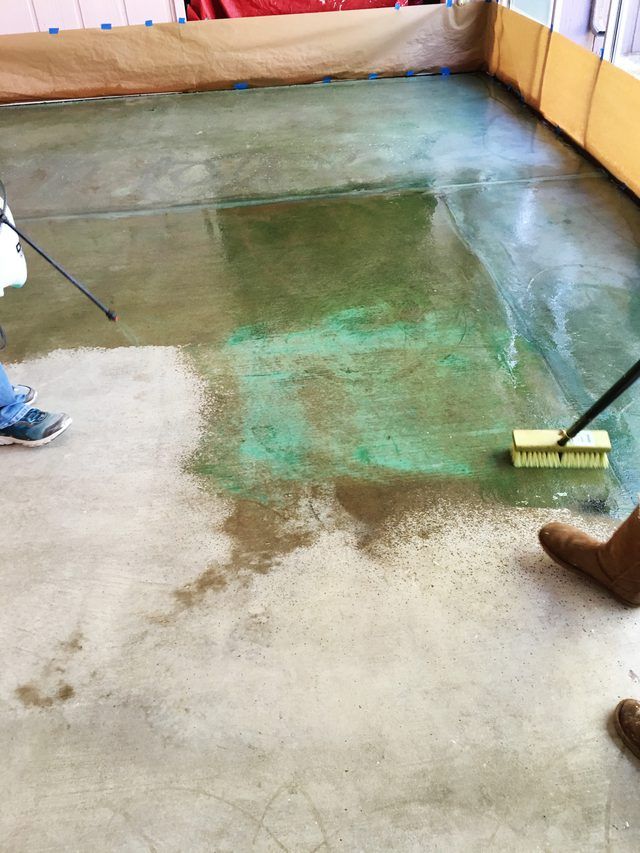 two people are cleaning the floor with brooms