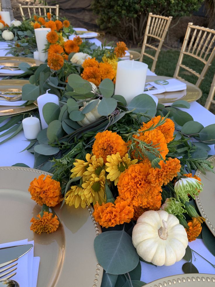 the table is set with candles, flowers and pumpkins for an elegant fall dinner