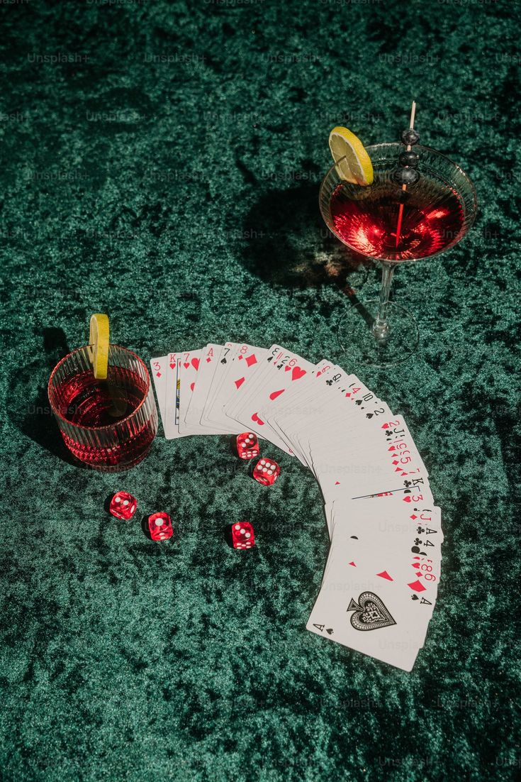 two cards and a drink sitting on the floor next to each other with dices in front of them