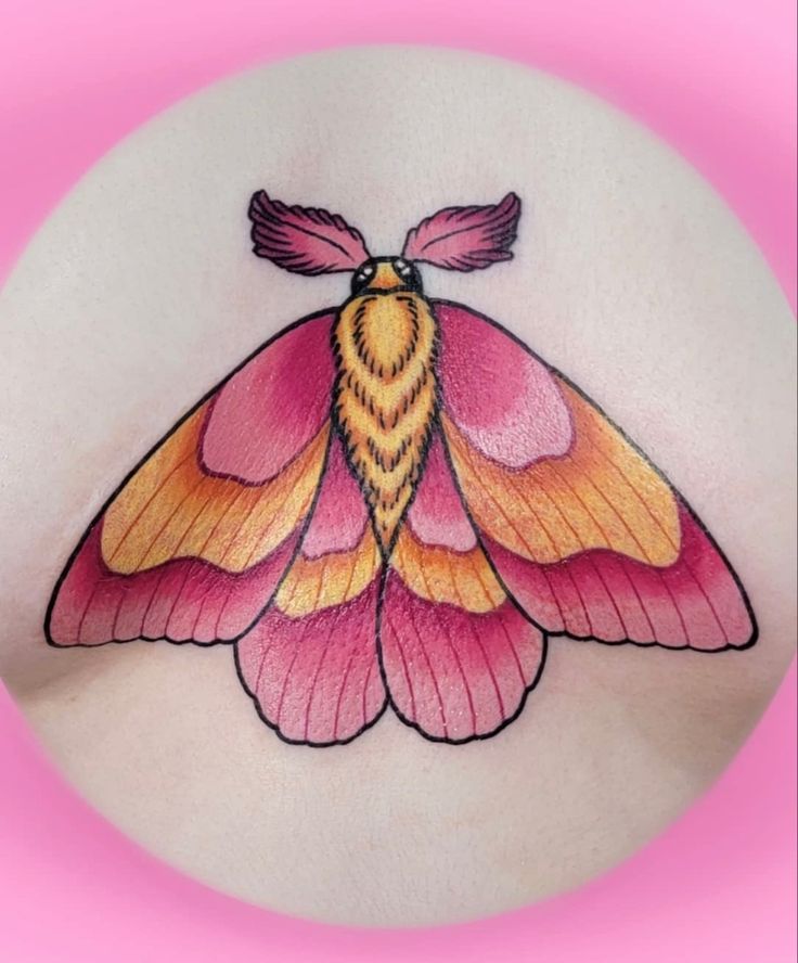 a pink and yellow moth tattoo on the stomach