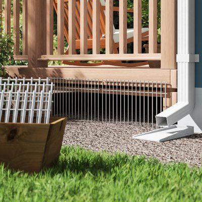 a wooden deck with white railings next to a potted plant in the grass