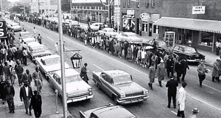 an old black and white photo of people walking down the street in front of cars