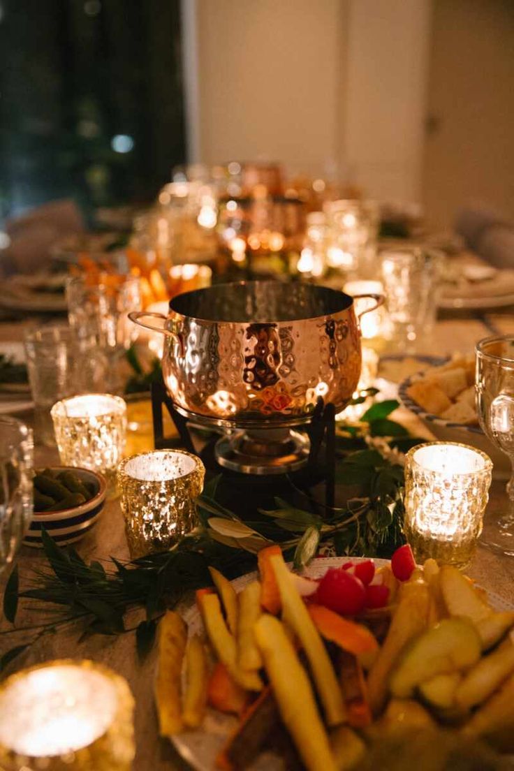 a table topped with lots of food and lit candles