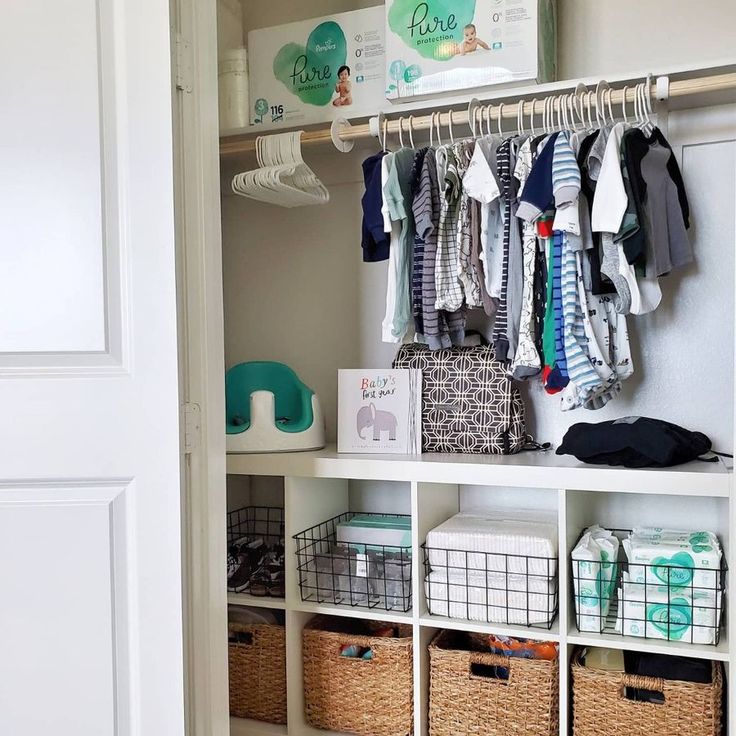 an organized closet with clothes hanging on the rack and other items in bins below