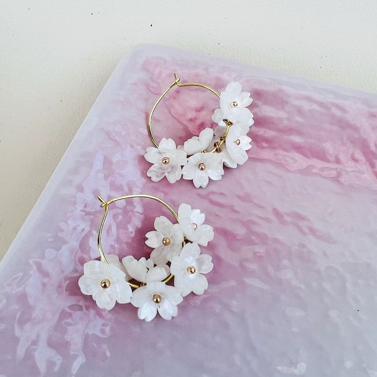 These exquisite hoop earrings feature delicate cherry blossom sakura flowers, available in either pink or white hues.  Each earring is meticulously handcrafted and the ear hoops are plated with  14K gold, exuding elegance and charm.  Perfect for adding a touch of whimsy and sophistication to any outfit, these earrings are versatile enough to be worn as bridal accessories or to elevate everyday looks with a dash of kawaii (cuteness). Earrings Kawaii, Hoop Earrings Handmade, Sakura Flowers, White Cherry Blossom, Kawaii Earrings, White Cherries, Sakura Flower, Earrings Ear, Threader Earrings