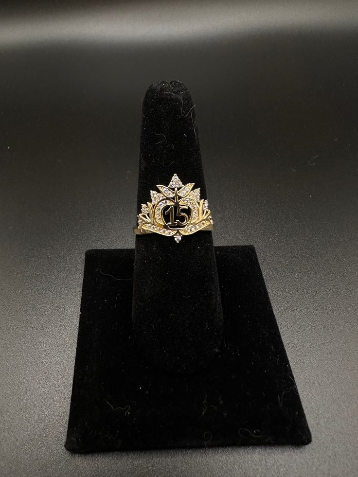 a gold ring sitting on top of a black velvet stand