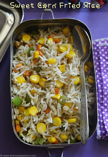 a metal container filled with rice and veggies on top of a purple table