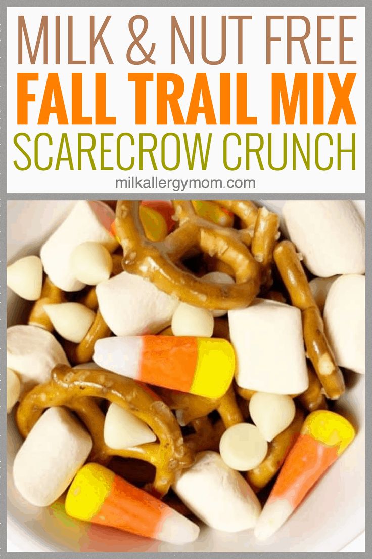 a white bowl filled with candy corn and pretzel trail mix on top of each other