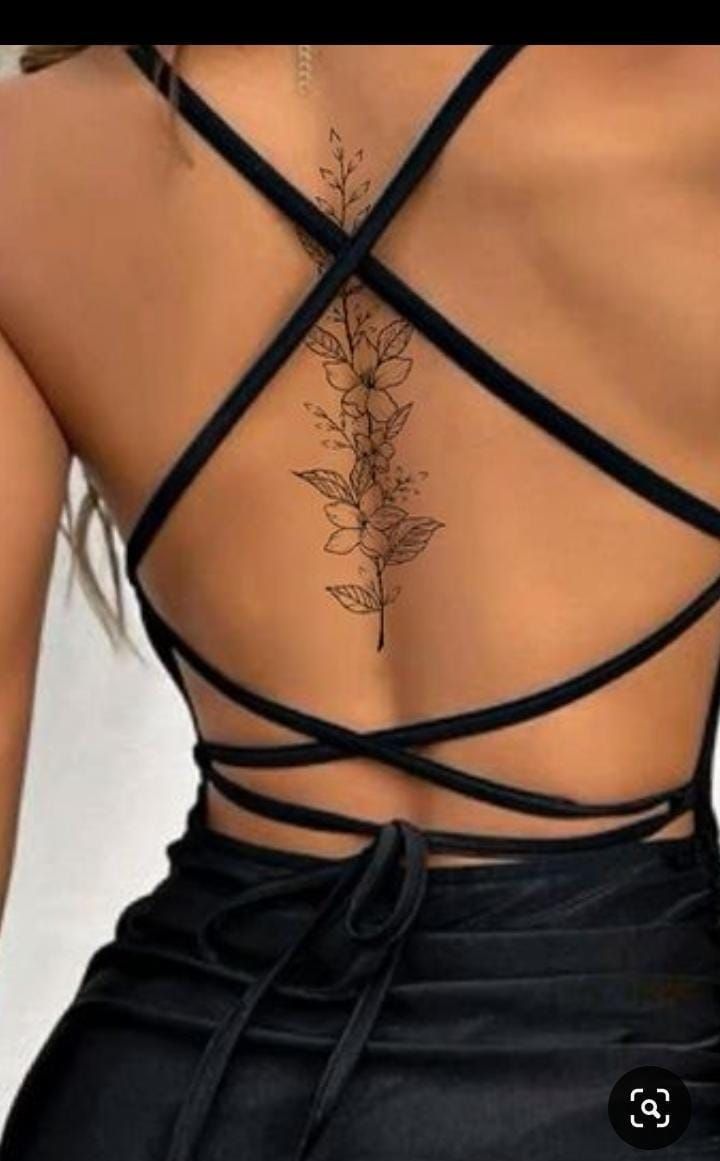 the back of a woman's dress with flowers on it and cross - over straps