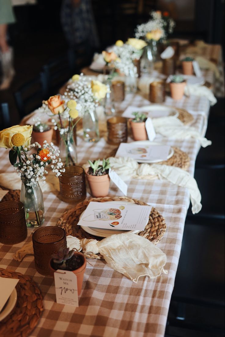 a long table is set with flowers and cards