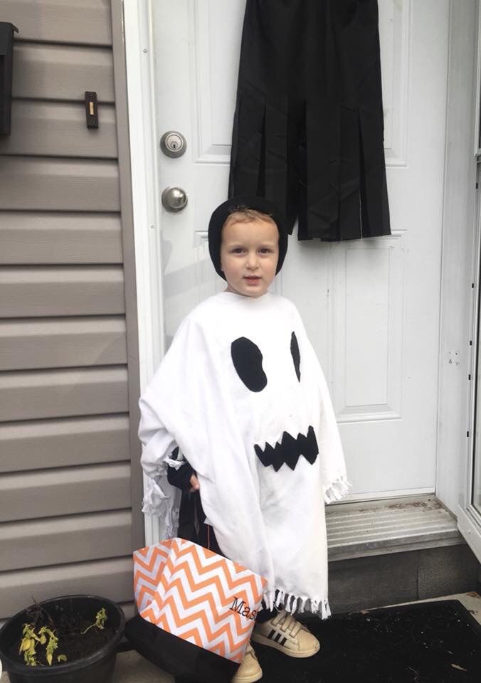 a little boy dressed up as a ghost