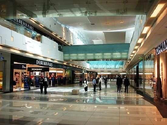 people are walking through an empty shopping mall