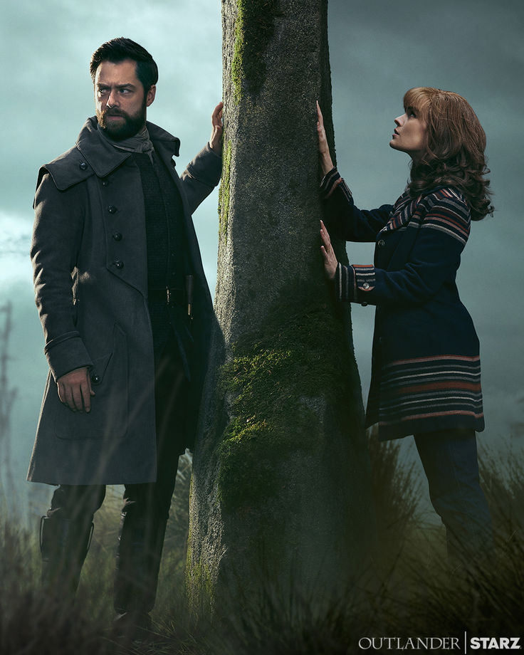 a man and woman standing next to a tree