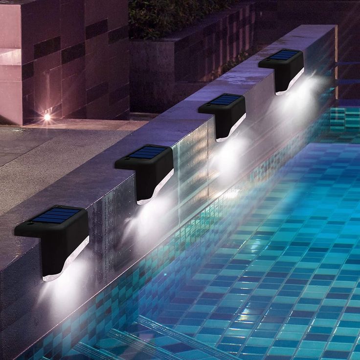 three lights are on the side of a swimming pool