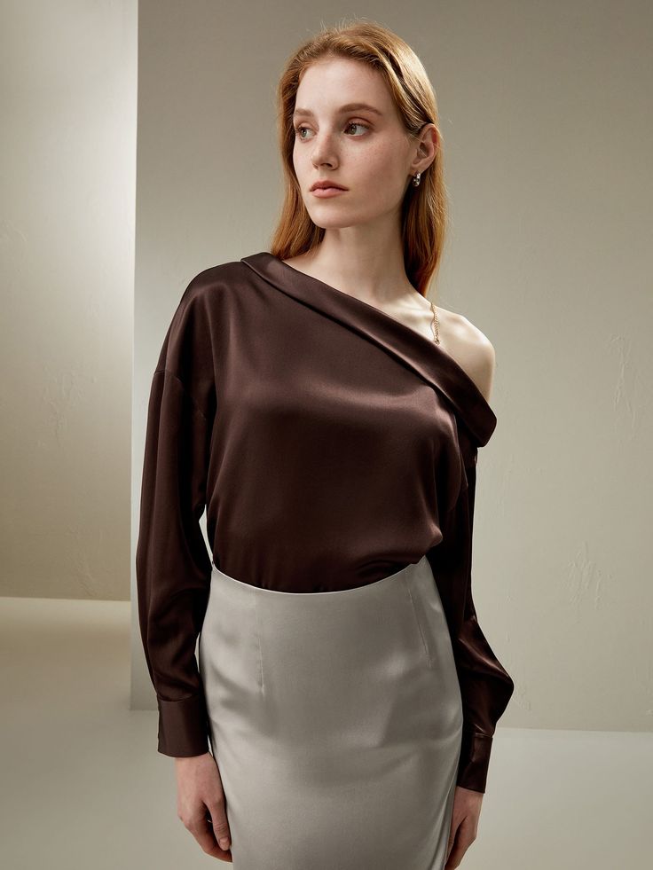 This stunning top features a slanted neckline with a narrow folded edge, creating an elegant and sophisticated look. The one-shoulder style adds a touch of allure, while the detachable light gold chain strap allows for versatile wearing options. The relaxed fit with dropped shoulders enhances the casual vibe, making it perfect for both dressy and casual occasions. Luxury Silk One-shoulder Top, Chic Luxury Tops With Folds, Luxury Chic Tops With Folds, Luxury Elegant Fitted Top, Luxury One Shoulder Formal Top, Luxury Elegant Long Sleeve One Shoulder Top, Luxury One Shoulder Top For Spring Party, Luxury Fitted Long Sleeve Top For Women, Luxury One Shoulder Top For Spring Formal Events