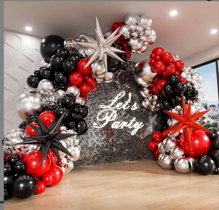 an entrance to a party decorated with black, red and silver balloons that say let's be merry