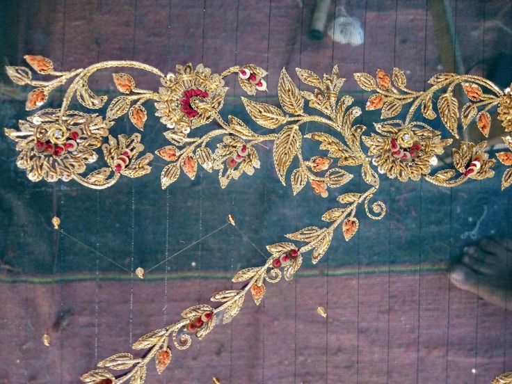 an elaborately designed piece of cloth with gold and red flowers on it's side