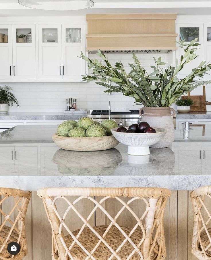 two wicker chairs sitting on top of a kitchen counter next to a bowl of fruit