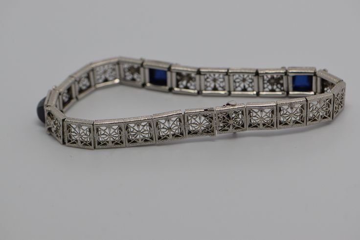 "14K white gold filigree sapphire bracelet in Art Deco style, Circa 1925, Platinum on 14K gold, 3 square sapphire stones, high dome cabochons, 7\" length, 1/4\" wide, weight 14.6 grams. Stock # BB90B19" Silver Rectangular Diamond Bracelet With 17 Jewels, Rectangular Silver Diamond Bracelet For Formal Occasions, Formal Silver Diamond Bracelet With Rectangular Shape, Formal Silver Rectangular Diamond Bracelet, Art Deco White Gold Bracelet For Formal Occasions, Formal Rectangular White Gold Bracelets, Formal Art Deco White Gold Bracelet, Art Deco Silver Diamond Bracelet Hand Set, Silver Art Deco Diamond Bracelet Hand Set